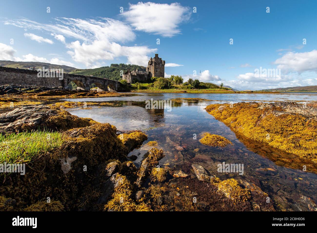Dornie, SCOTLAND: Summer days with a blue sky above the beautiful Scottish castle of Eilean Donan in the middle of a lake. Stock Photo