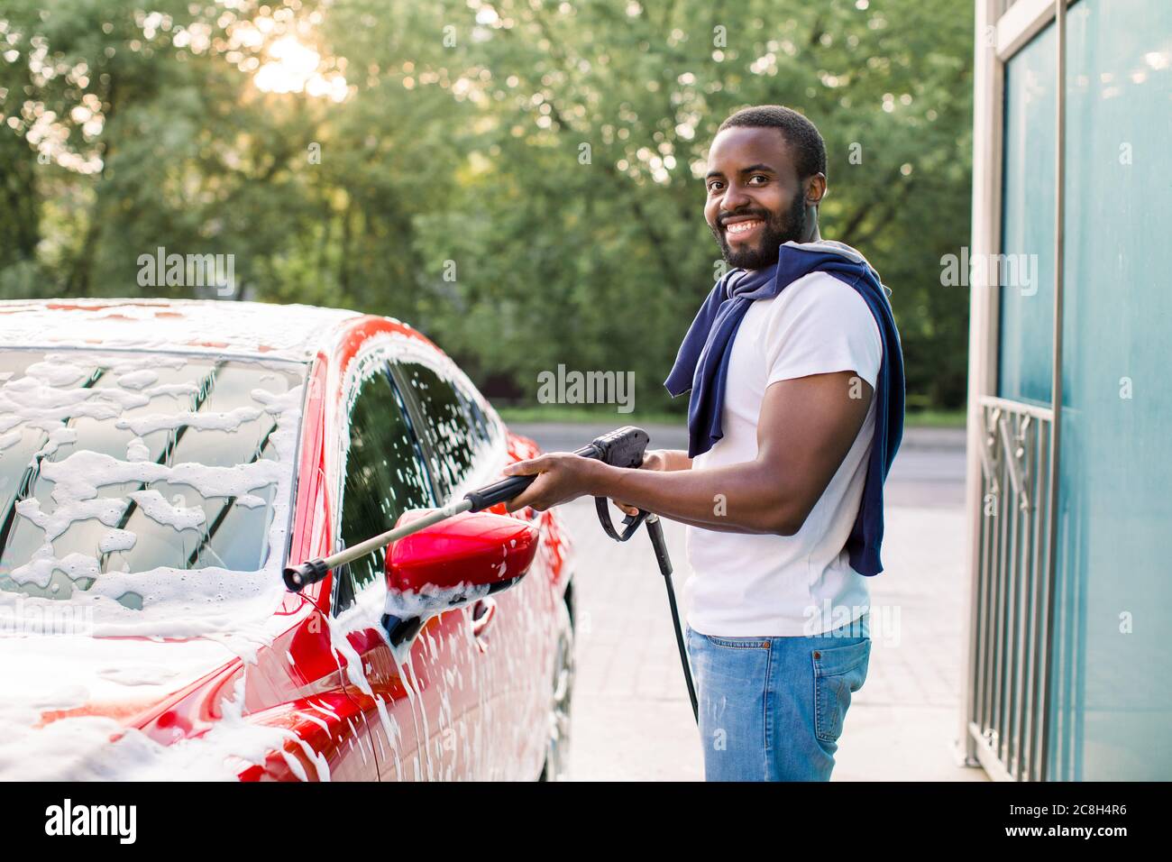 Cleaning car using active foam. Man washing his car on self car-washing  Stock Photo - Alamy