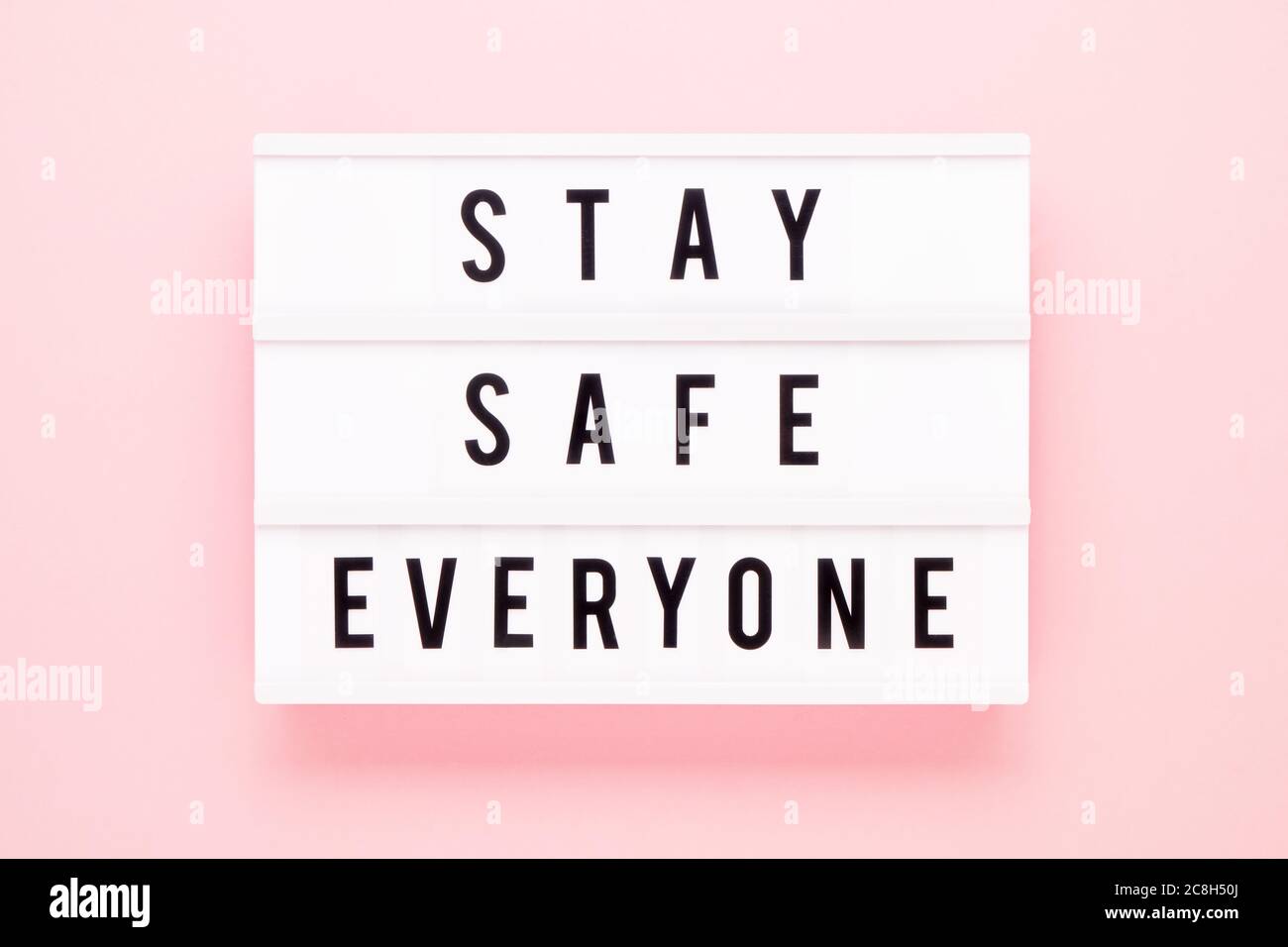 STAY SAFE EVERYONE written in lightbox on pink background. Healthcare and medical concept. Top view. Quarantine concept. Stock Photo