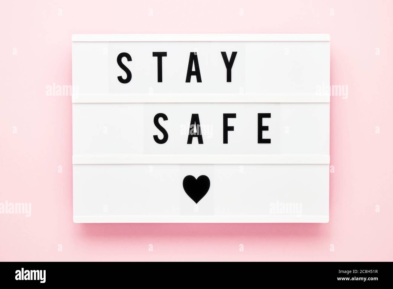 STAY SAFE written in light box on pink background. Healthcare and