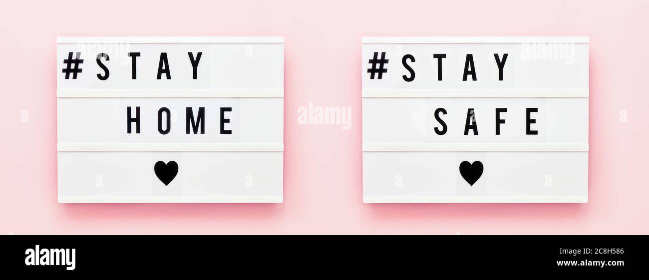 STAY AT HOME, STAY SAFE written in light box on pink background. Healthcare and medical concept. Top view. Quarantine concept. Banner Stock Photo