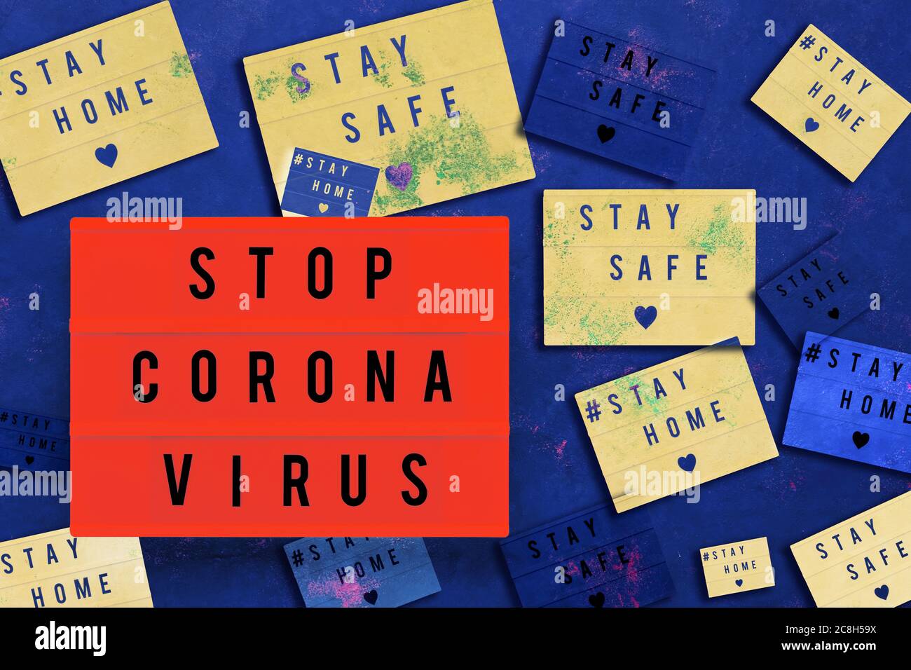 TOP CORONA VIRUS, STAY HOME and STAY SAFE written in light box on blue background. Healthcare and medical concept. Top view. Quarantine concept. Colla Stock Photo