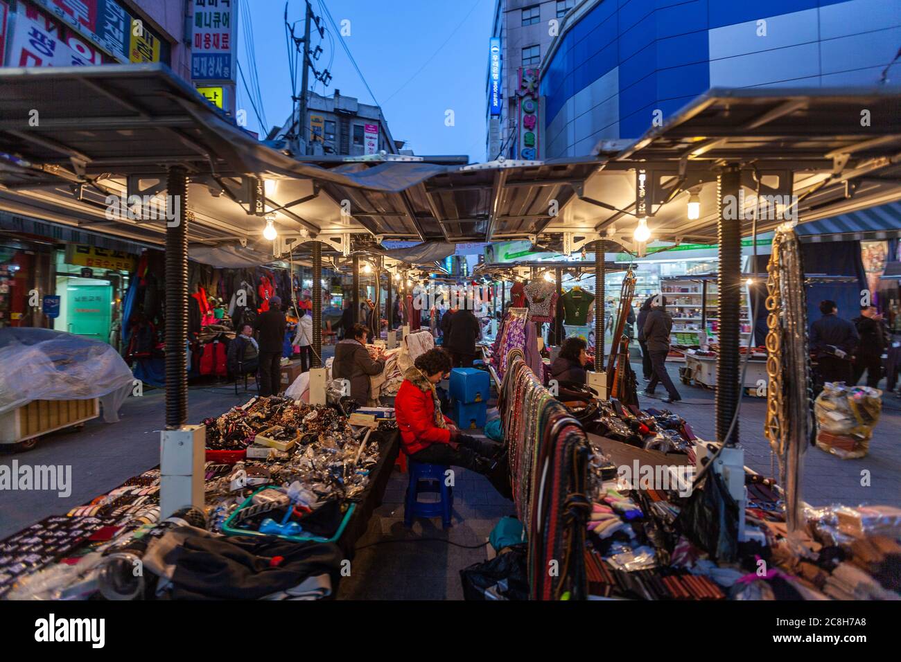 Street vendors in a busy night narrow street with stalls and shops in