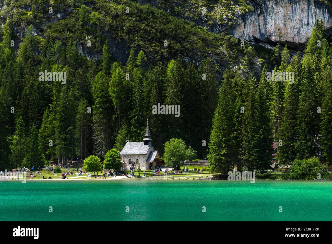 Tourists visit the church on Lake Braies in the dolomite mountains Stock Photo