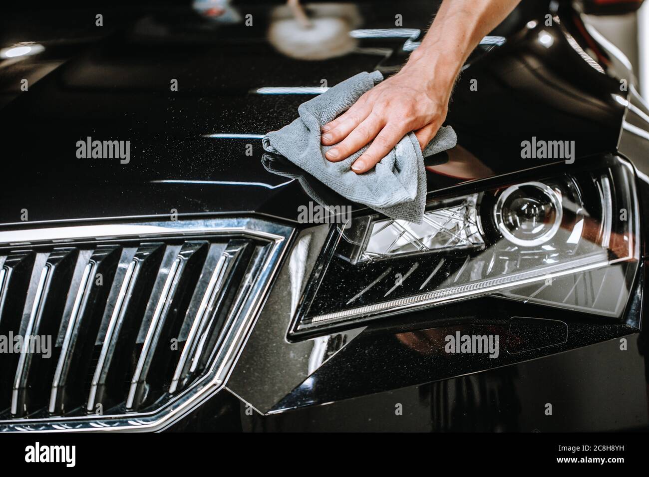 Professional detailing a car in car studio, hands with orbital polisher