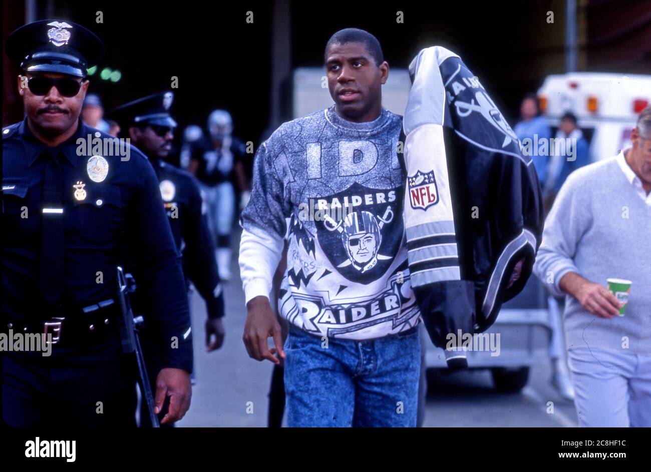 Magic Johnson of the Lakers arriving at the Los Angeles Coliseum dressed in Raiders gear to watch an L.A. Raiders NFL football game in 1991. Stock Photo