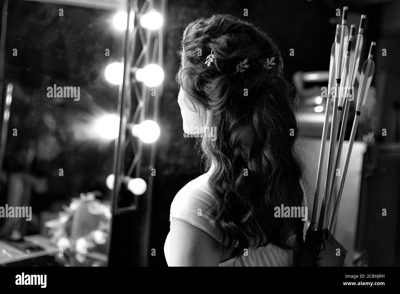 Black and white image of archer woman from back in white dress with bow and  arrow on studio lights on background. Greek goddess Artemis. Professional  Stock Photo - Alamy