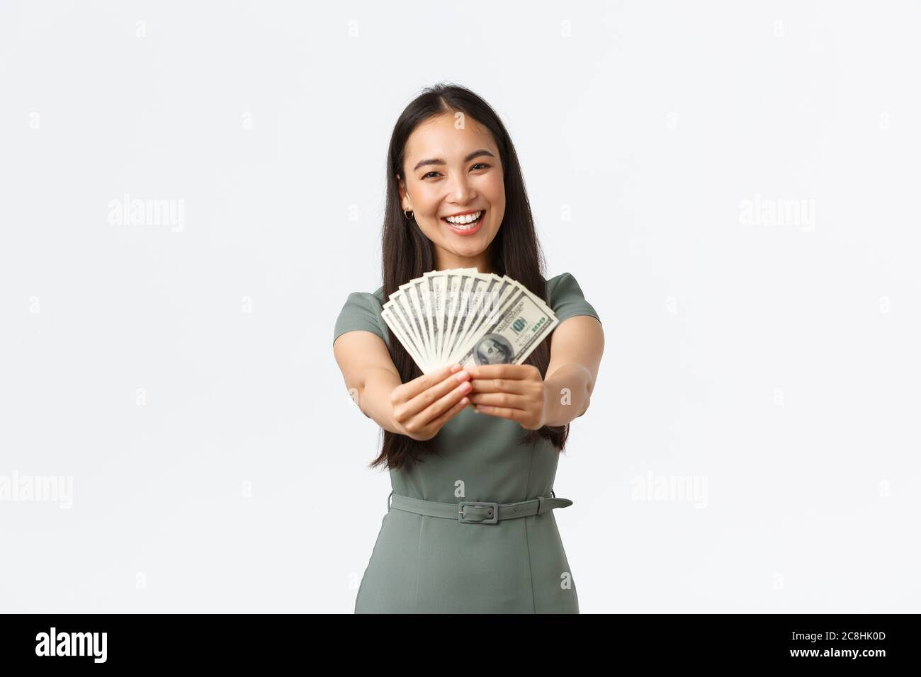 Happy smiling asian female business owner, shop manager showing money she earned at online store, holding cash and rejoicing, show-off with her income Stock Photo