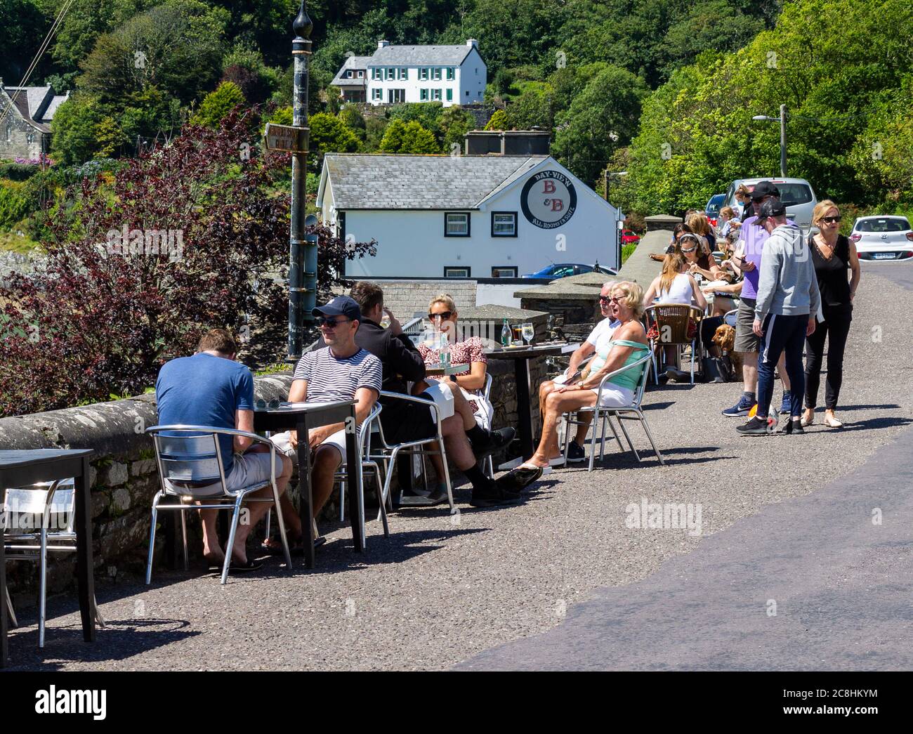 People eating outdoors on the seafront Glandore West Cork Ireland Stock Photo