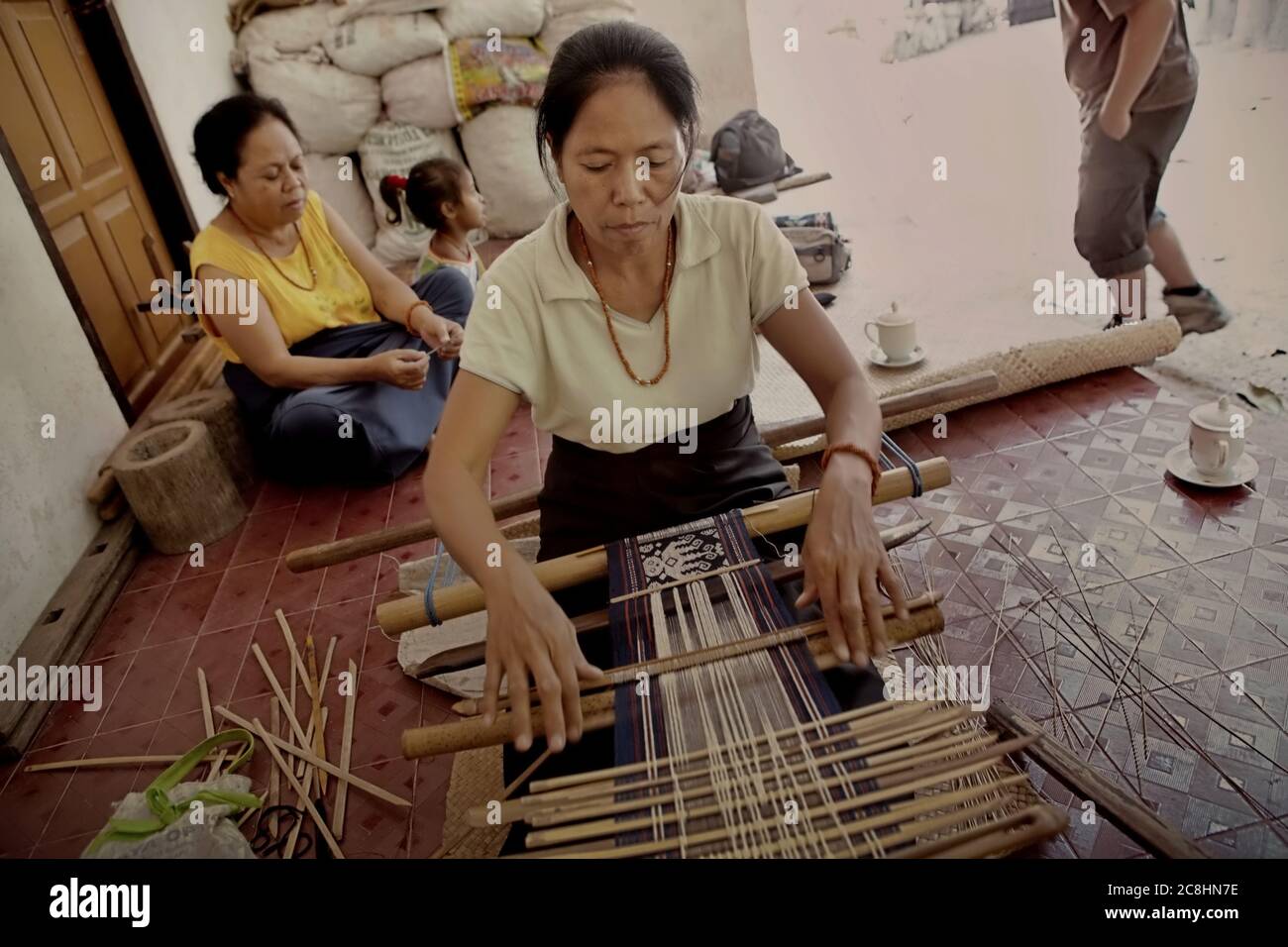 A woman making a traditional Sumba textile in Umabara, Pau, Sumba Island, Indonesia. Stock Photo