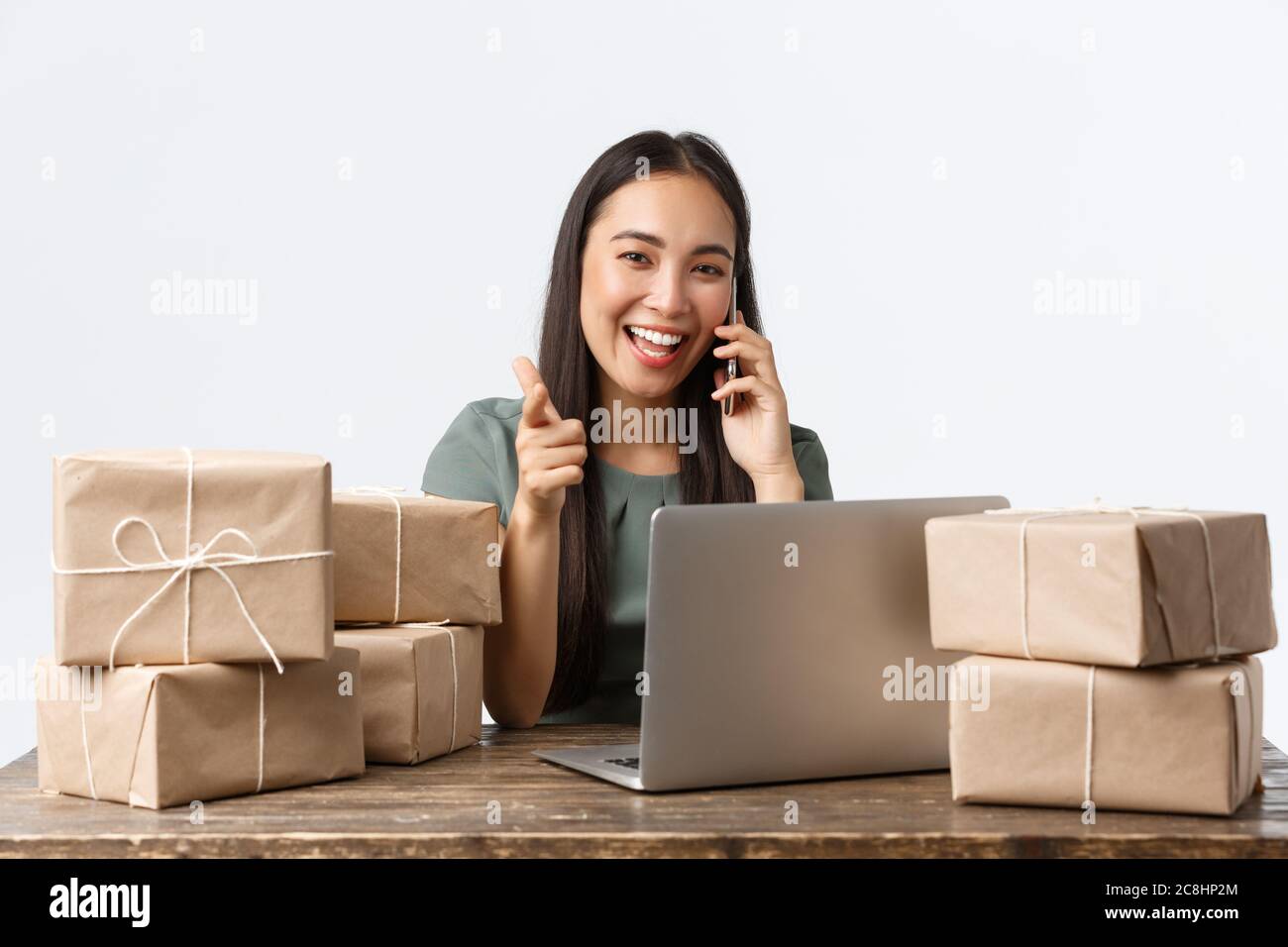 Small business owners, startup and e-commerce concept. Smiling asian businesswoman, online store manager pointing camera, answering client call Stock Photo