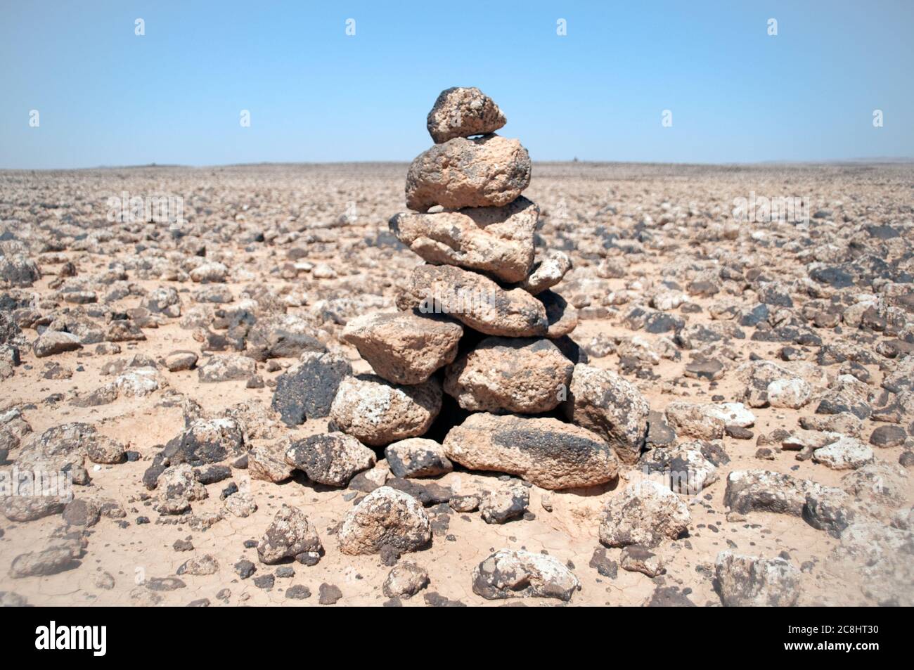 A cairn of basalt rocks from ancient volcanoes cover the eastern desert, or 'black desert,' in the Badia region of the Hashemite Kingdom of Jordan. Stock Photo