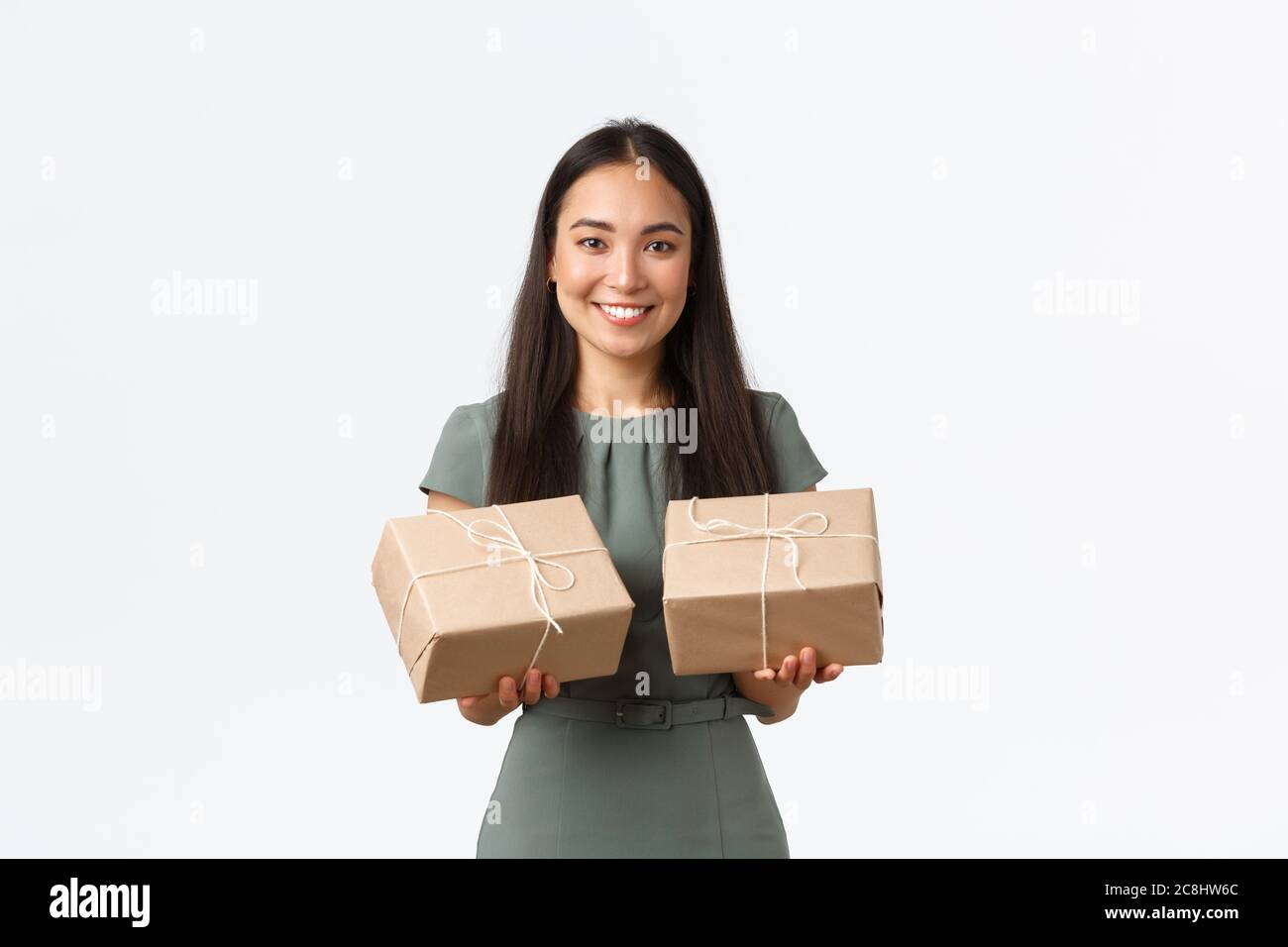 Smiling happy asian female small business owner, manage internet store, packing items for shipping to clients, holding to packaged ready for delivery Stock Photo