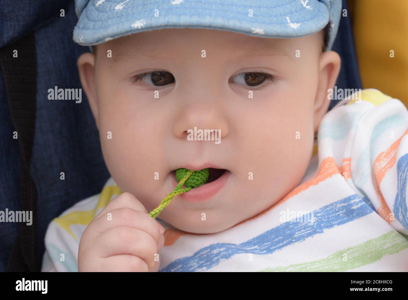 Little baby bites and gnaws wooden balls Stock Photo Alamy