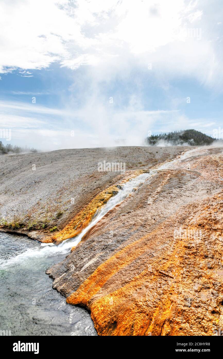 Hot water runoff from Excelsior Geyser flowing into the Firehole River at Yellowstone National Park's Midway Geyser Basin. Stock Photo