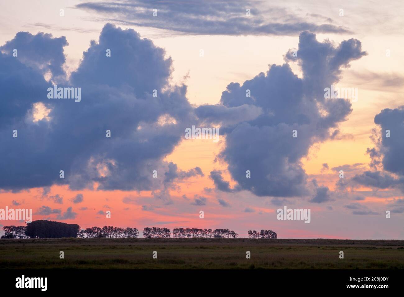 Clouds over a field in Normandy, France at dusk Stock Photo