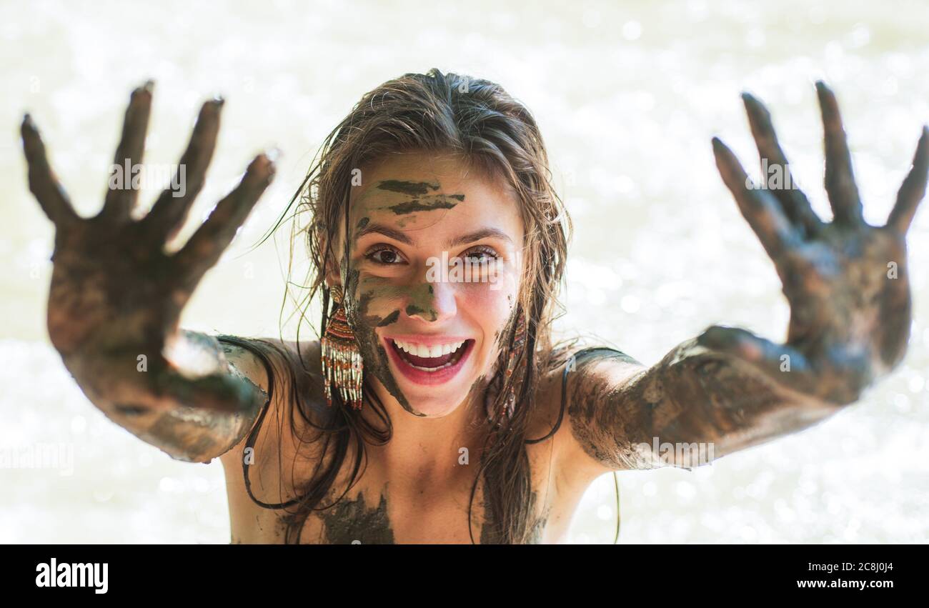 Woman with natural mud mask. Muddy hands. Spa Outdoor. Happy dirty