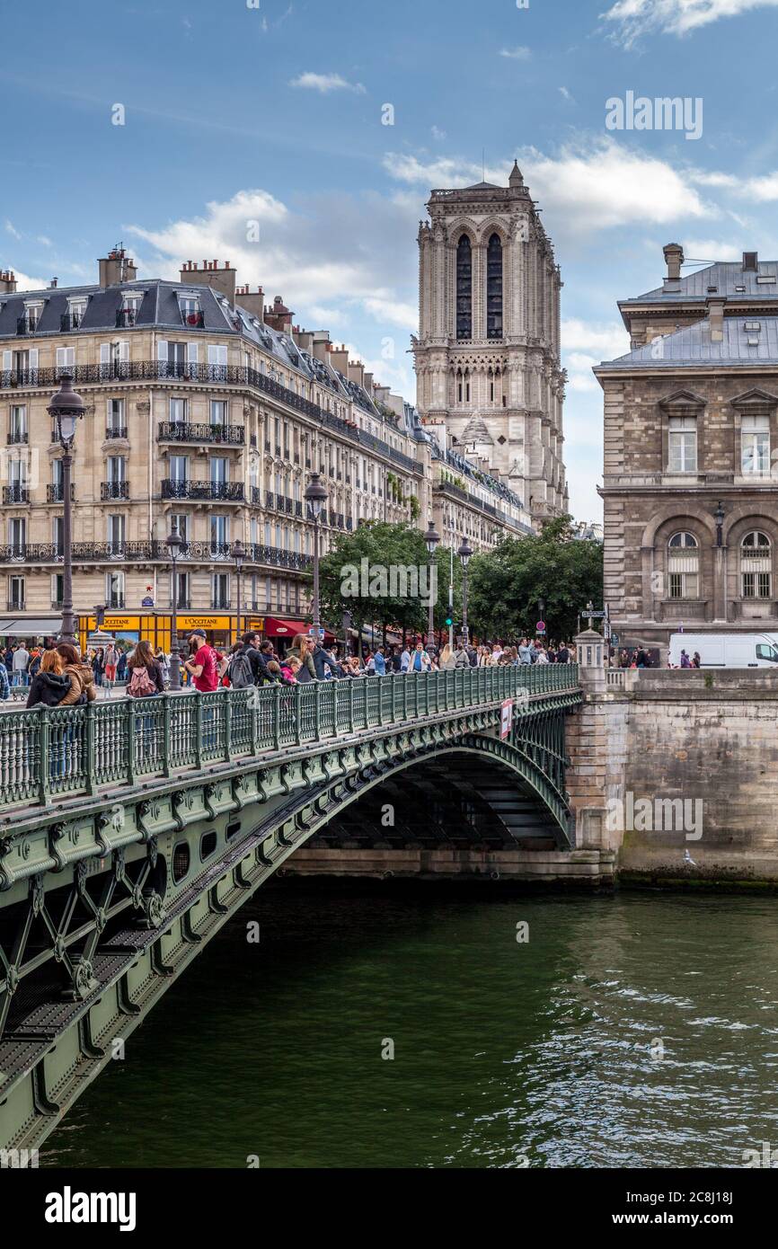 Crossing a bridge in Paris in view of Notre Dame cathedral Stock Photo