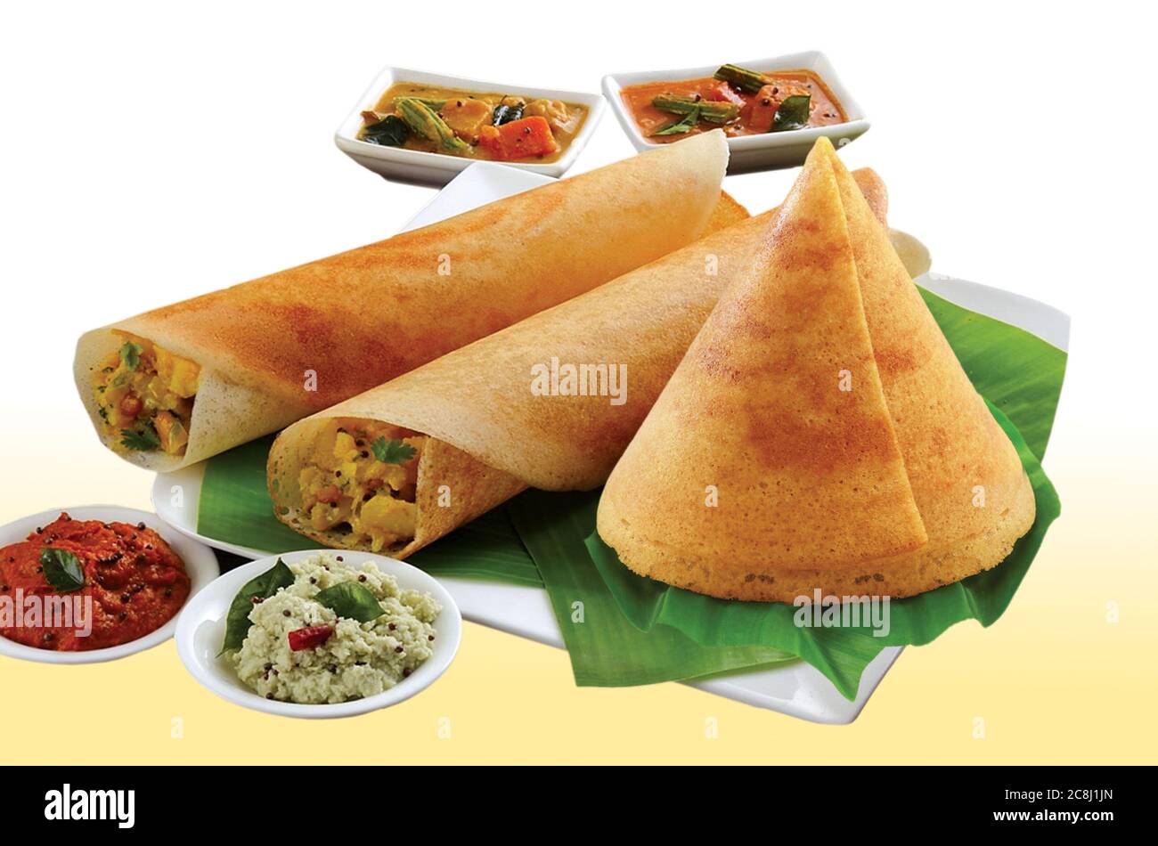 Group of South Indian food like Paper Masala Dosa (dhosa), Idli or idly, Wada or vada (Medu Vada), sambhar, sambar and coconut chutney, white backgrou Stock Photo