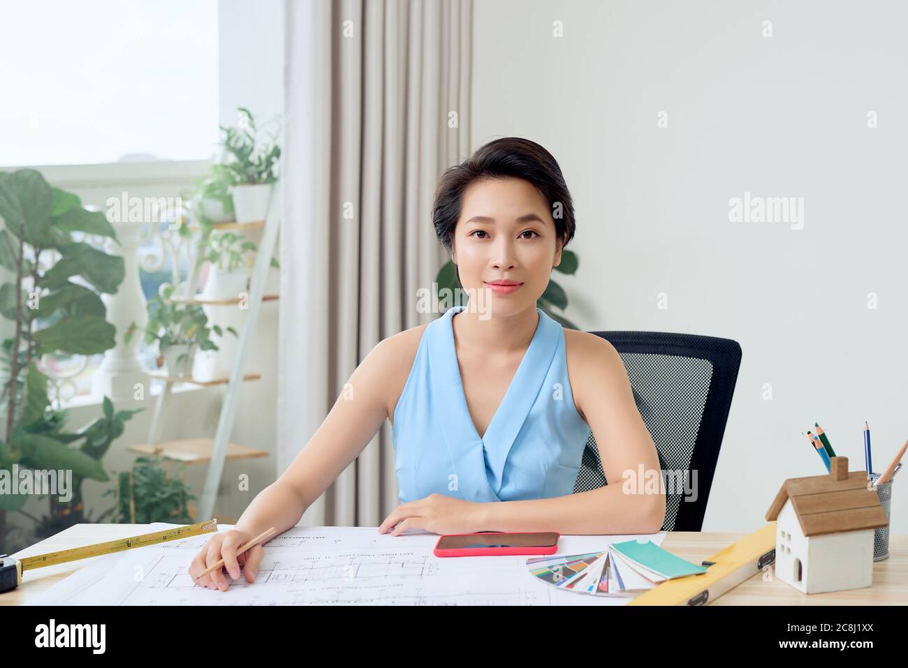 Portrait of young Asian architect sitting in her office Stock Photo