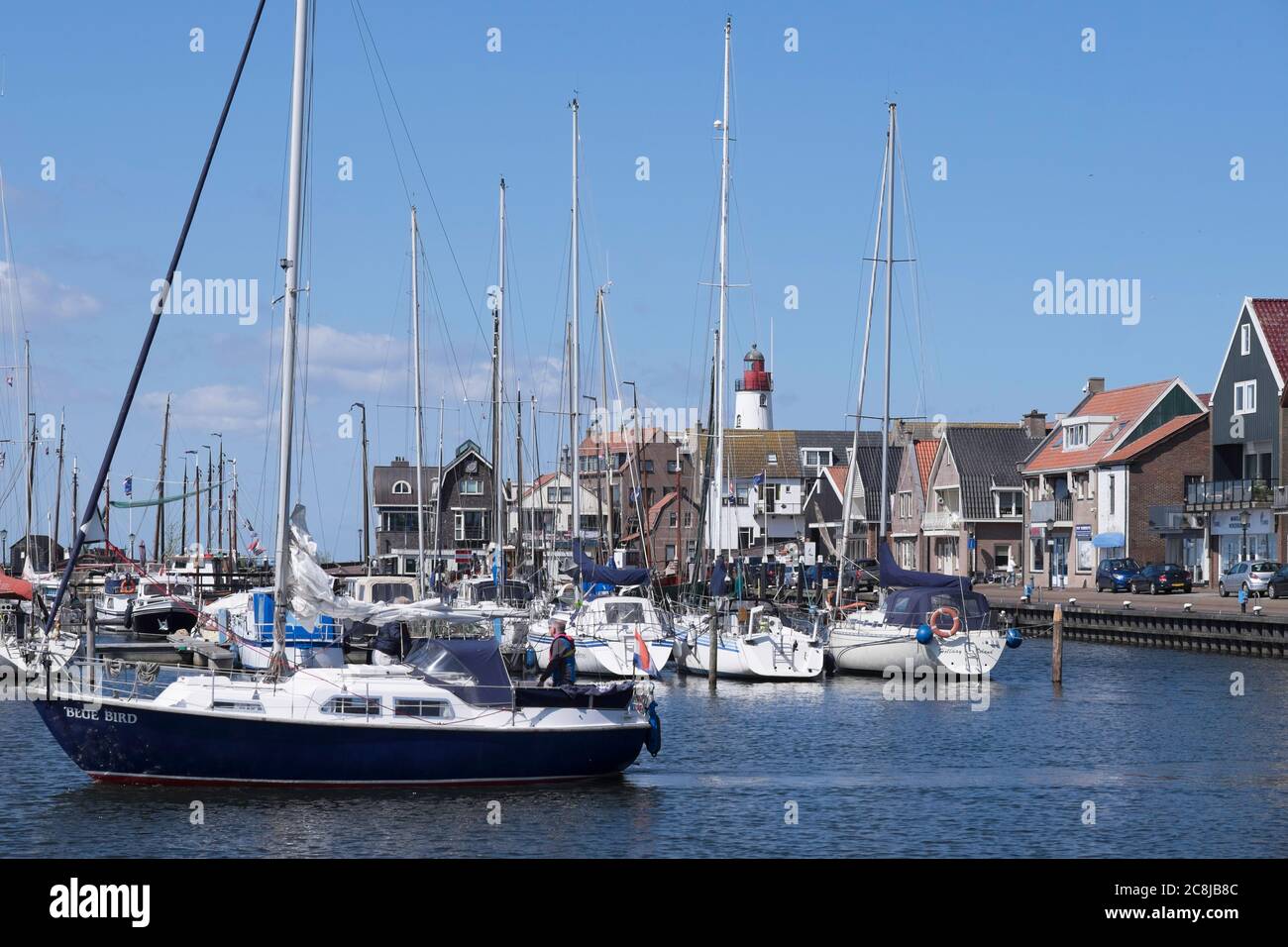 Harbor of small fishing town Urk west harbour with fishing and sailing boats and lighthouse. Center former island of Urk alongside the IJsselmeer Stock Photo