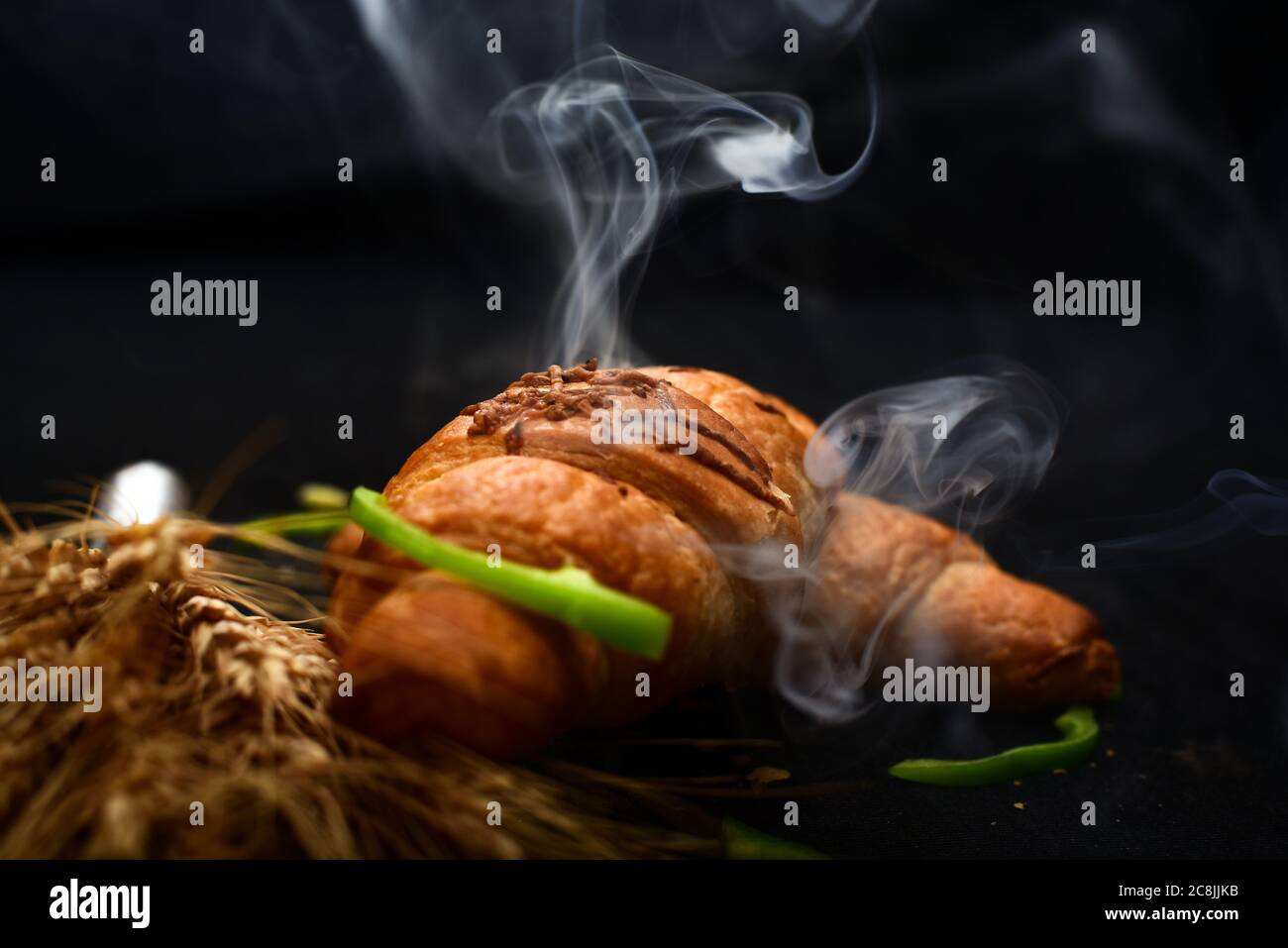 hot chilli wheat bread with steam on black background.Food background and wallpapers Stock Photo