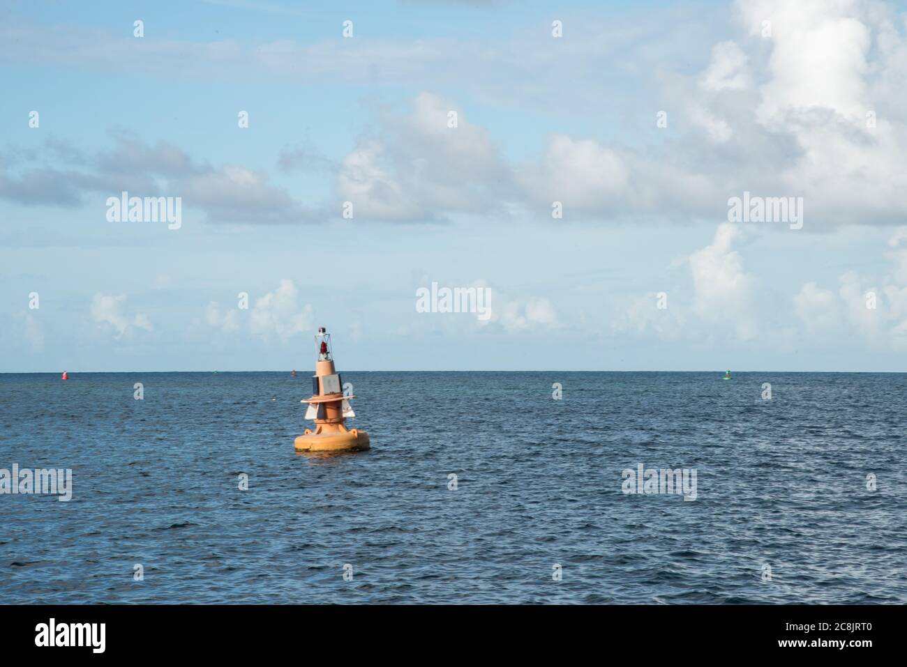 Buoy floating in the rippling Caribbean Sea under a blue sky with ...