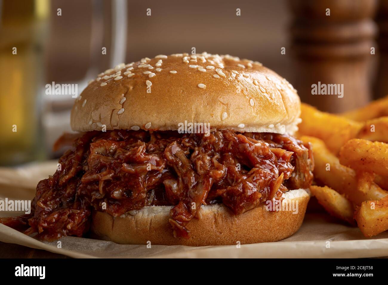 Barbecue pulled pork sandwich on a sesame seed bun with french fries Stock Photo Alamy