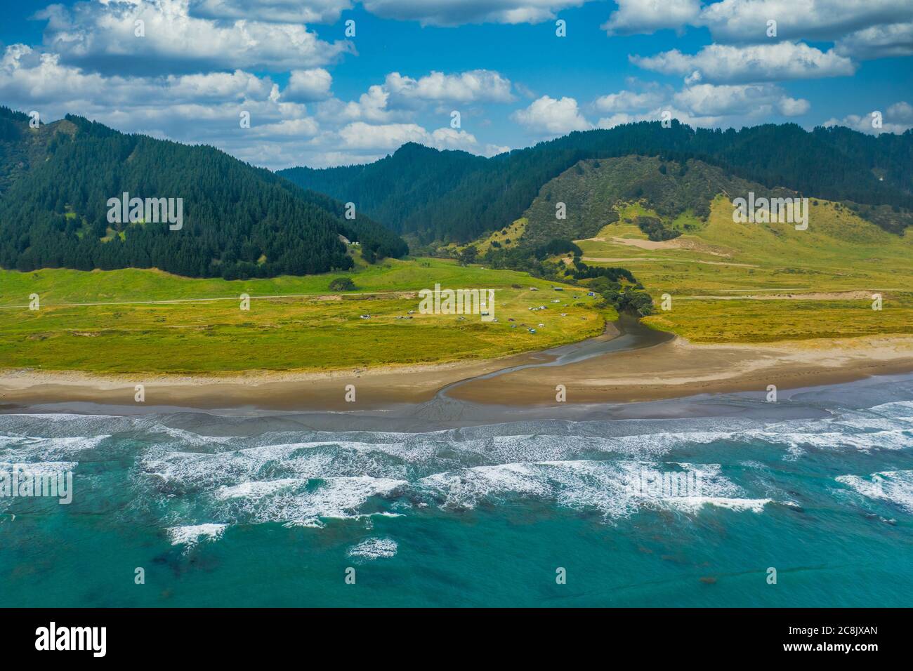 An aerial view of East Cape Campground next to the Pacific Ocean. Located on the eastern tip of the North Island of New Zealand. Mountains a forest le Stock Photo