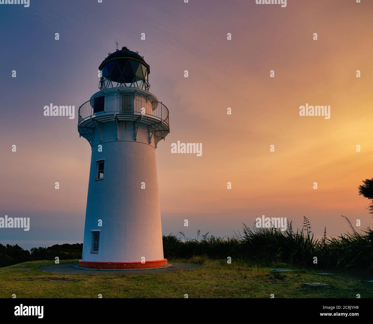 East Cape lighthouse is on the eastern tip of the North Island of New Zealand. This photograph was taken at sunset during summer. Stock Photo