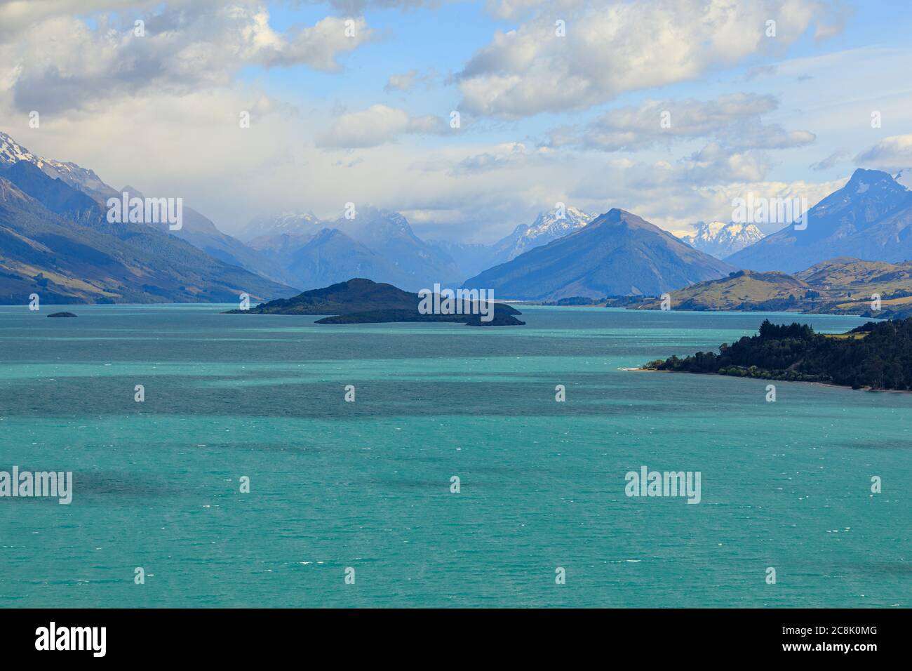 The view of Lake Wakatipu with clouds covering the snow-capped mountains in the distance. From the view of Bennetts Bluff Lookout. Stock Photo