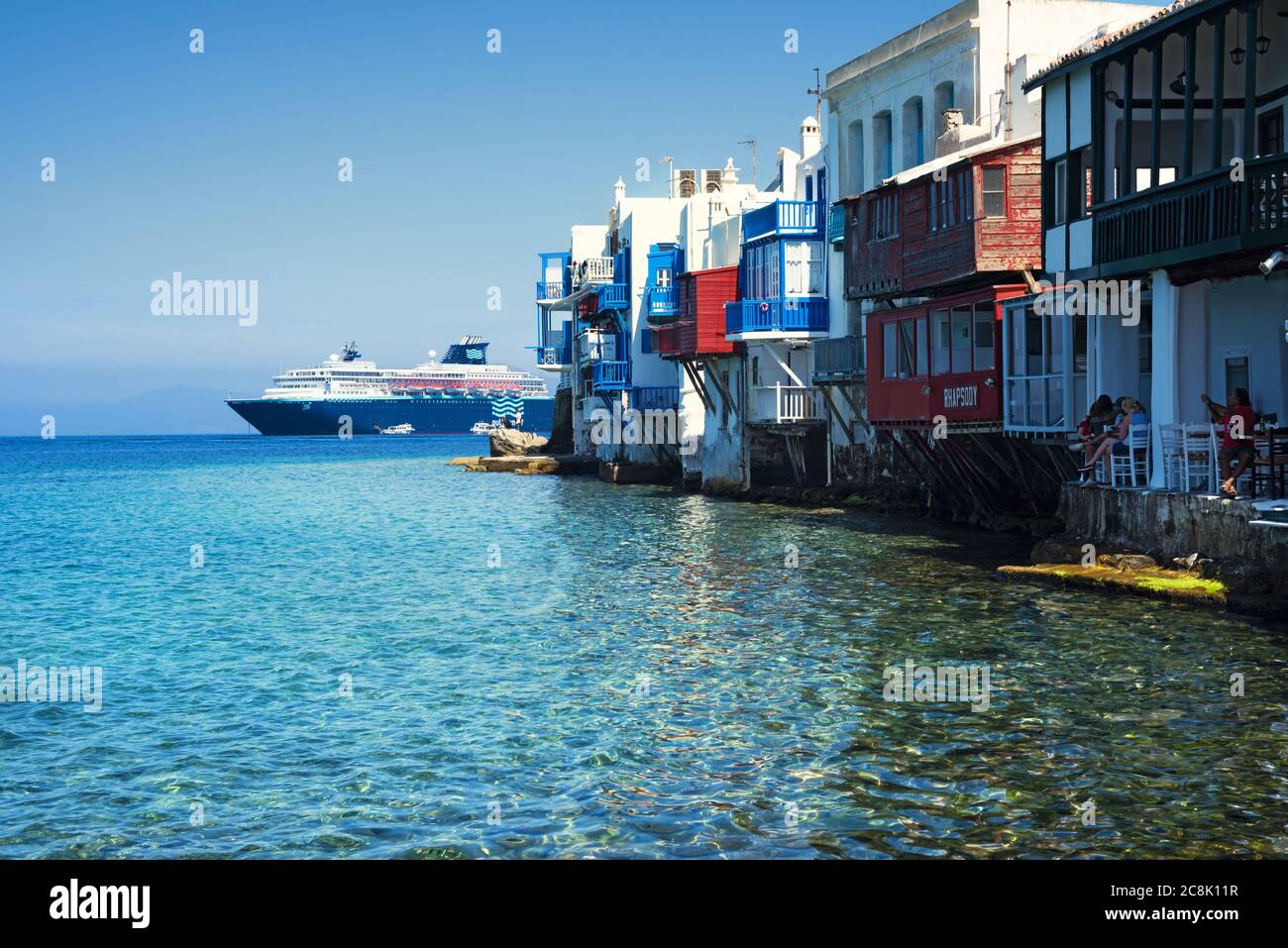 Picturesque houses by the sea against cruise ship. Mykonos, Greece Stock Photo