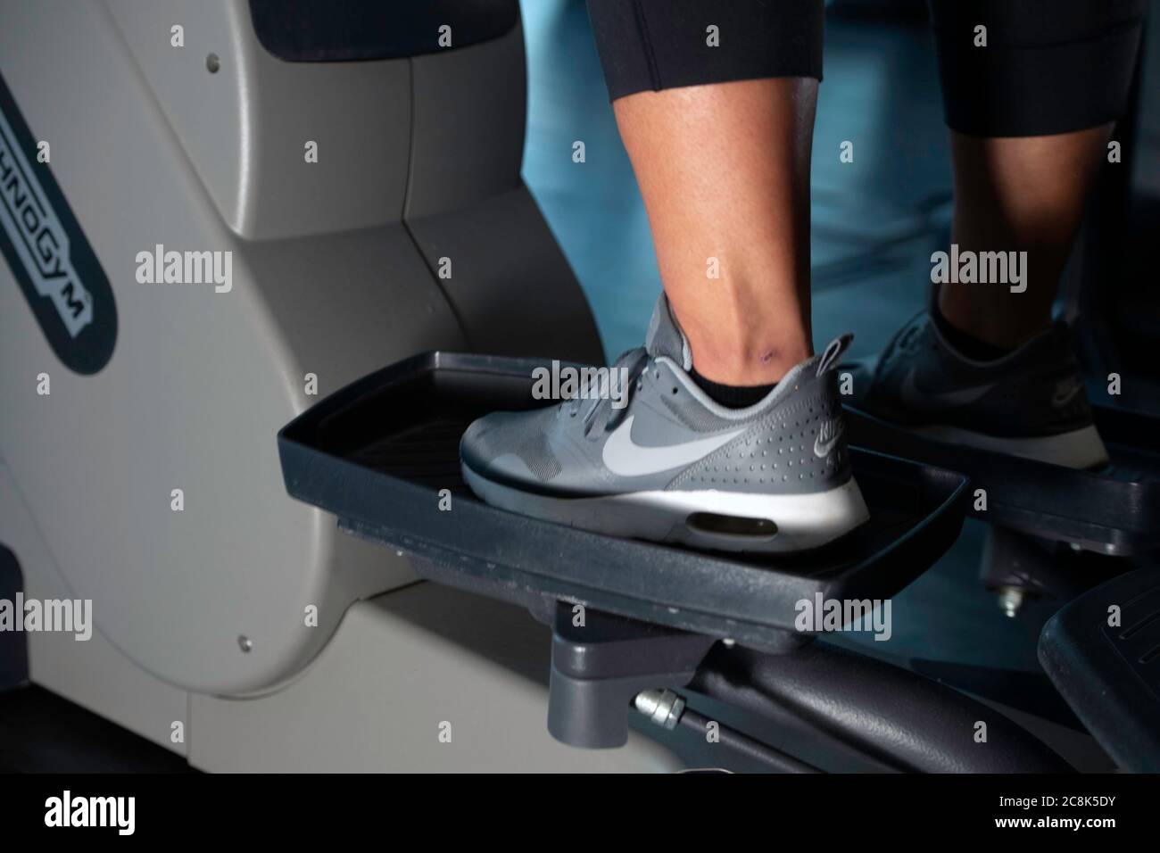 Woman's foot on step machine in Gym Stock Photo