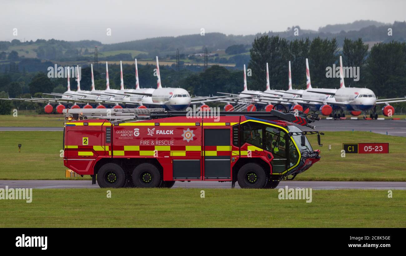 Glasgow, Scotland, UK. 23 July 2020. Pictured: Glasgow Airport Fire Service truck seen training against a backdrop of grounded British Airways (BA) Airbus A319/A320/A321 aircraft sit the second runway of Glasgow Airport awaiting their fate of being sold off or put in storage.  Since March these planes have been sitting idle on the the airports tarmac, doe to the global coronavirus (COVID19) crisis. Credit: Colin Fisher/Alamy Live News. Stock Photo