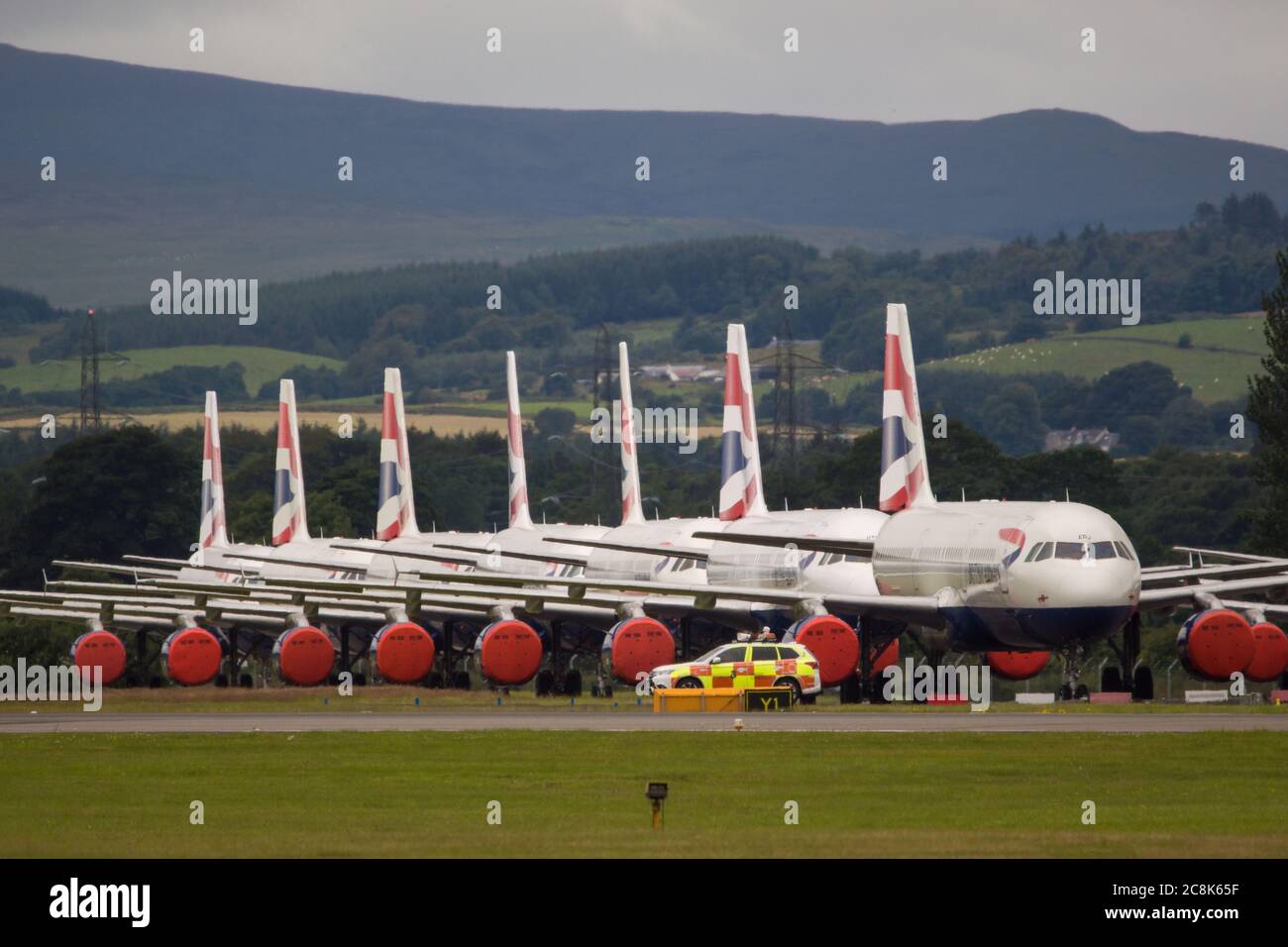 Glasgow, Scotland, UK. 23 July 2020. Pictured: A backdrop of grounded British Airways (BA) Airbus A319/A320/A321 aircraft sit the second runway of Glasgow Airport awaiting their fate of being sold off or put in storage.  Since March these planes have been sitting idle on the the airports tarmac, doe to the global coronavirus (COVID19) crisis.  British Airways have cut almost 12,000 staff, and to date have retired their whole Boeing 747 fleet in a bid to cut operating costs. Credit: Colin Fisher/Alamy Live News. Stock Photo