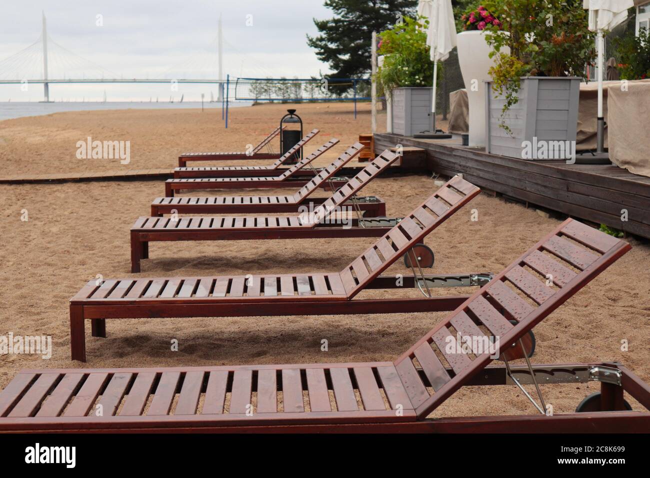 Bad weather in the city in summer. Raindrops on sun loungers. Closed cafe. An empty beach with no people Stock Photo