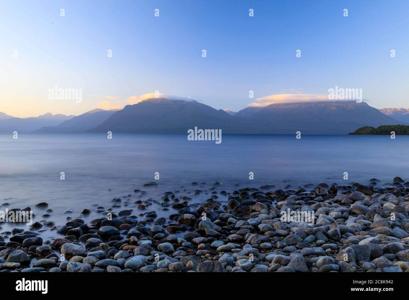 Rocky at the shore of Lake Te Anau at Department of Conservation, DOC, Henry Creek Campsite at sunset. Stock Photo