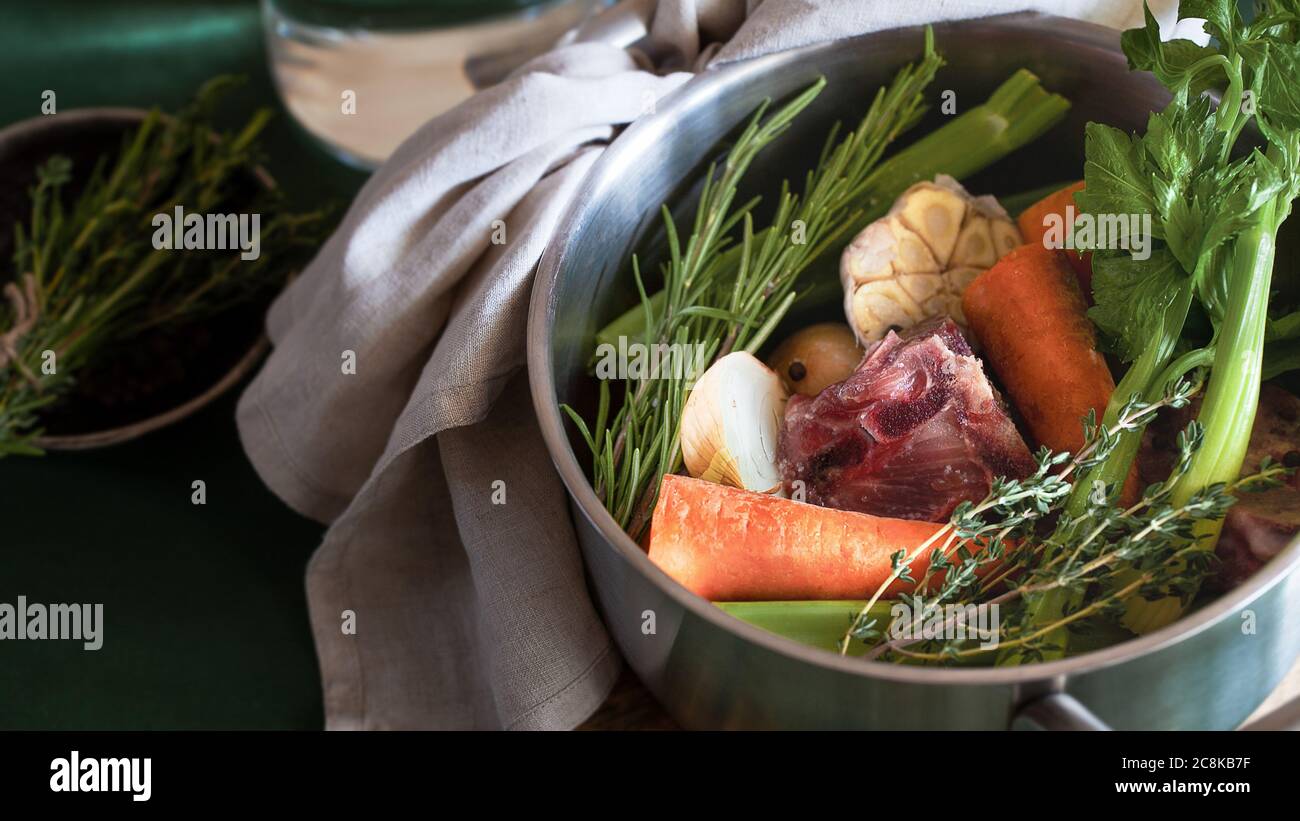 Ingredients for cooking bone broth. Stock pot with veggies, herbs, and