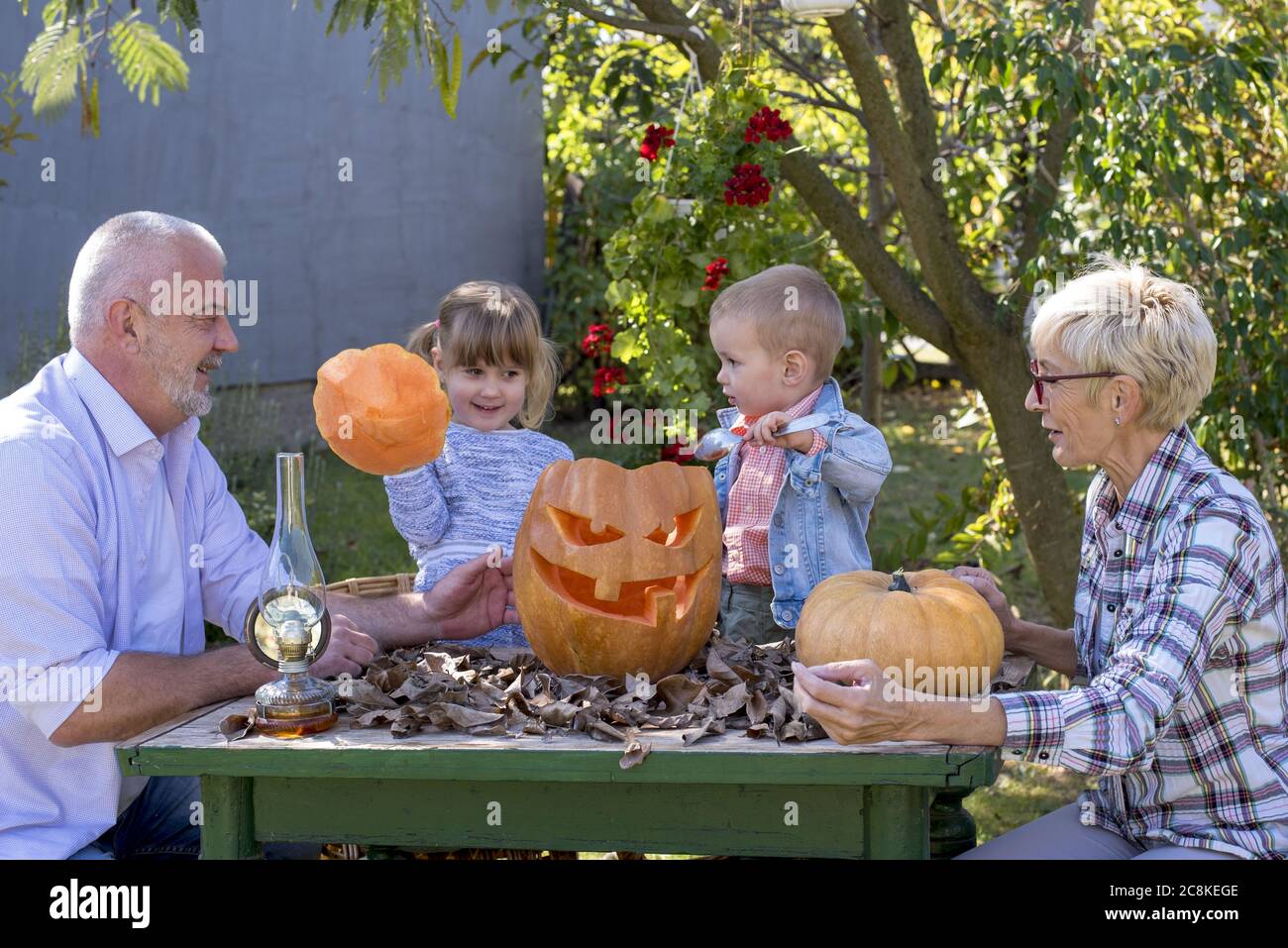 Closeup shot of grandparents helping children to carve a pumpkin for Halloween Stock Photo - Alamy