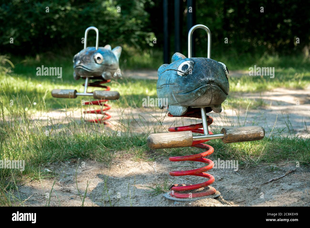 Wooden hand crafted fish spring rocker in a playground Stock Photo