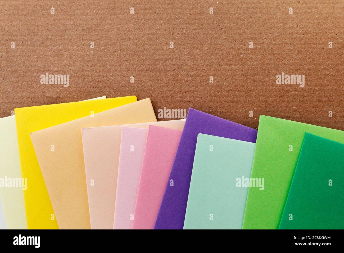 Colorful envelopes on brown paper background, copy space. Stock Photo