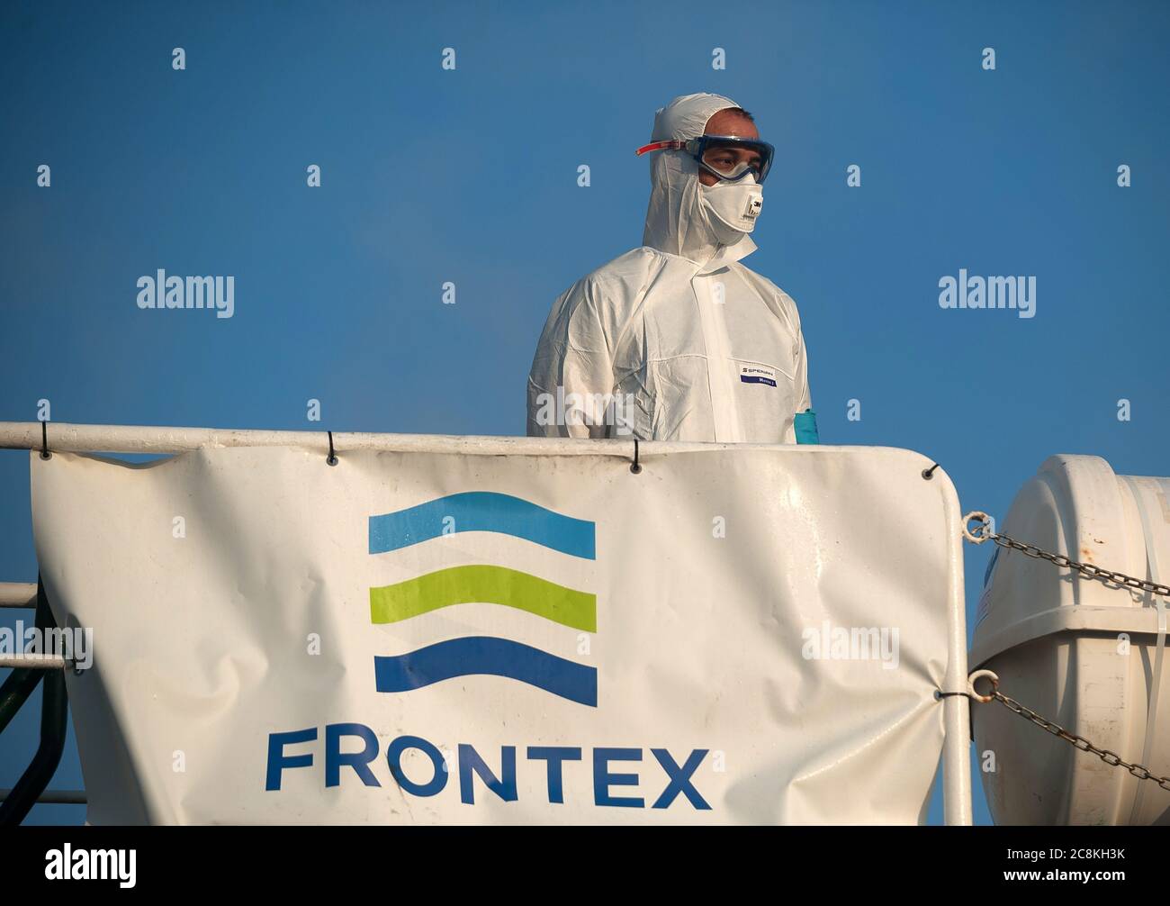 A member of European Border and Coast Guard Agency (Frontex) dressed in a protective suit on a patrol vessel at Malaga port after intercepted a dinghy on the Mediterranean Sea.A Spanish Civil Guard vessel intercepted around 82 Algerian migrants near Almeria's coast while trying to reach Europe by small boats. During the coronavirus pandemic, the closure of Morocco's border with Spain as a measure to prevent the spread of coronavirus disease has caused a drastic drop in the number of migrants that try to reach the Spanish coasts across Alboran Sea route, while the arrival of migrants to Canary Stock Photo