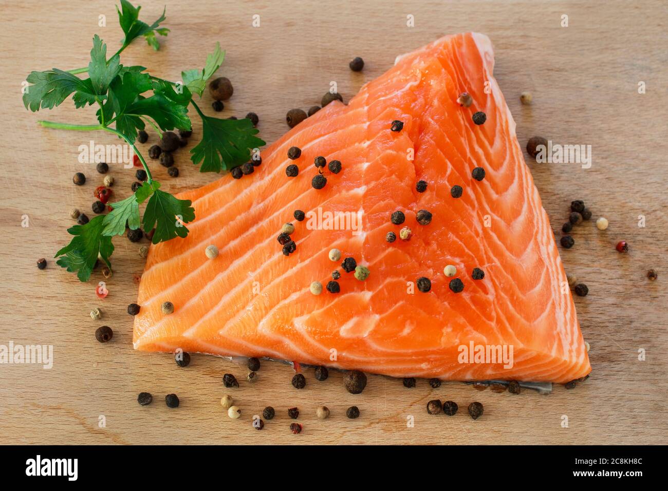 Raw salmon meat with spices. Cooking time Stock Photo