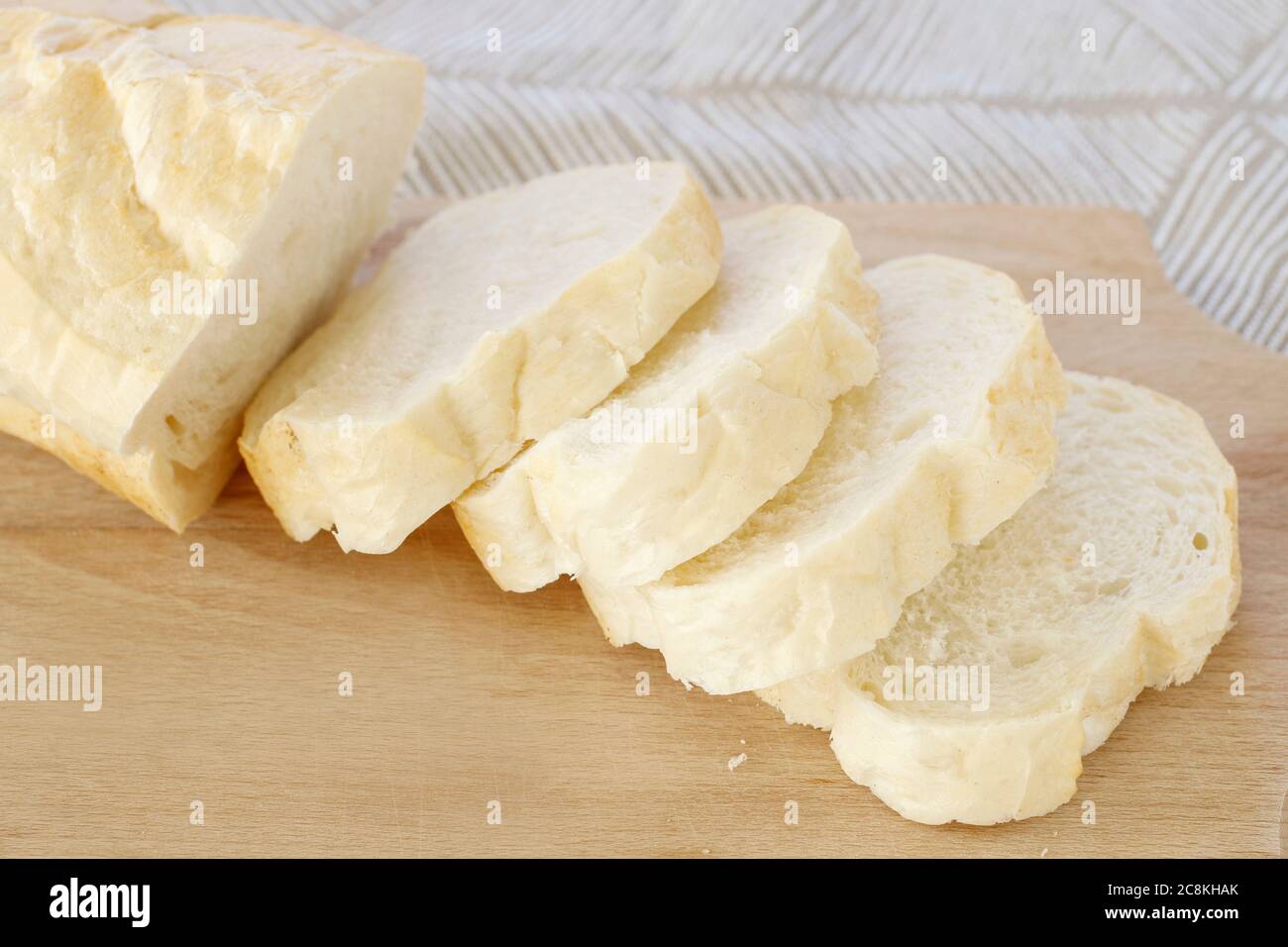 Sliced bread on wooden cutting board. Breakfast time Stock Photo