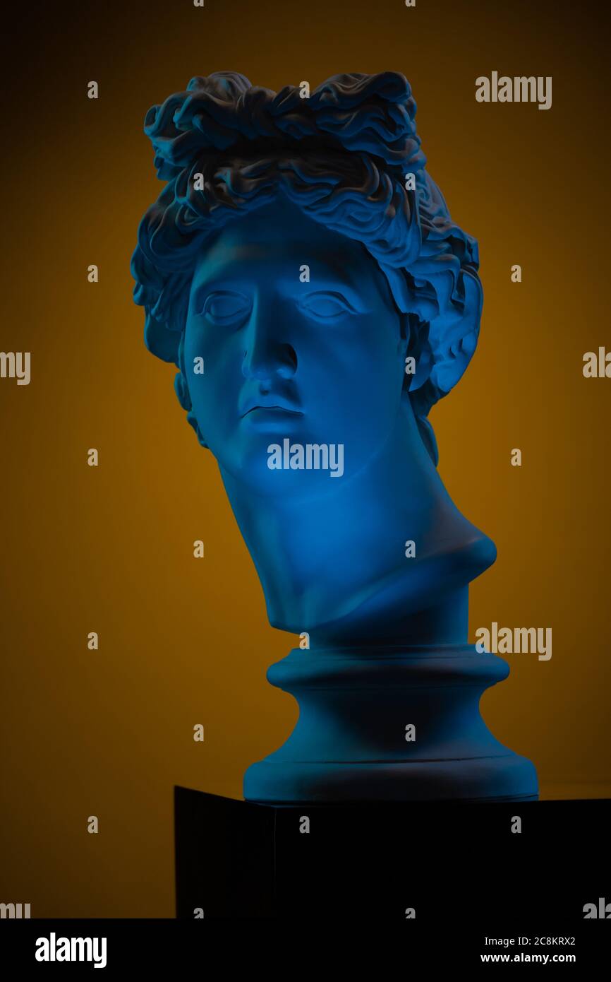 Plaster statue of a bust of Apollo Belvedere in blue local light on a