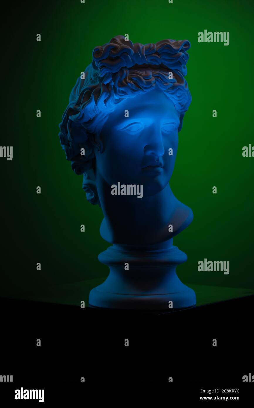 Plaster statue of a bust of Apollo Belvedere in blue local light on a