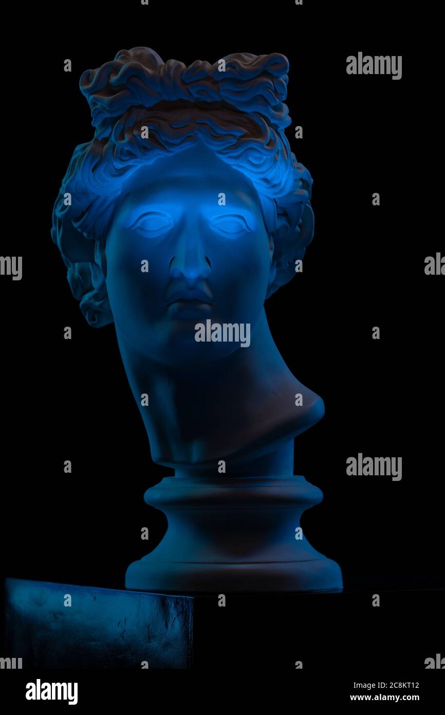 Plaster statue of a bust of Apollo Belvedere in blue local light on a