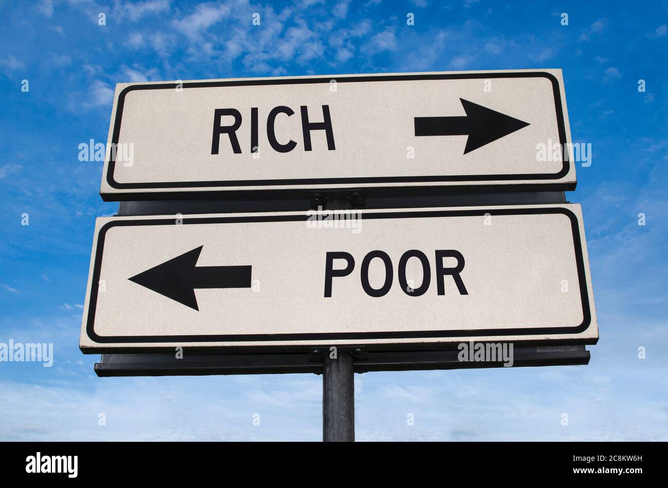 Rich and poor road sign. White two street signs with arrow on metal pole with word. Directional road. Crossroads Road Sign, Two Arrow. Blue sky Stock Photo