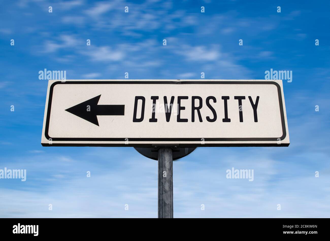 Diversity road sign, arrow on blue sky background. One way blank road sign with copy space. Arrow on a pole pointing in one direction. Stock Photo