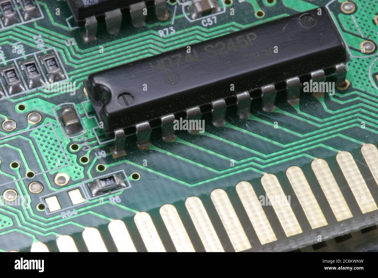 Electronic circuit board with close up macro with black IC soldered in on green board. Stock Photo